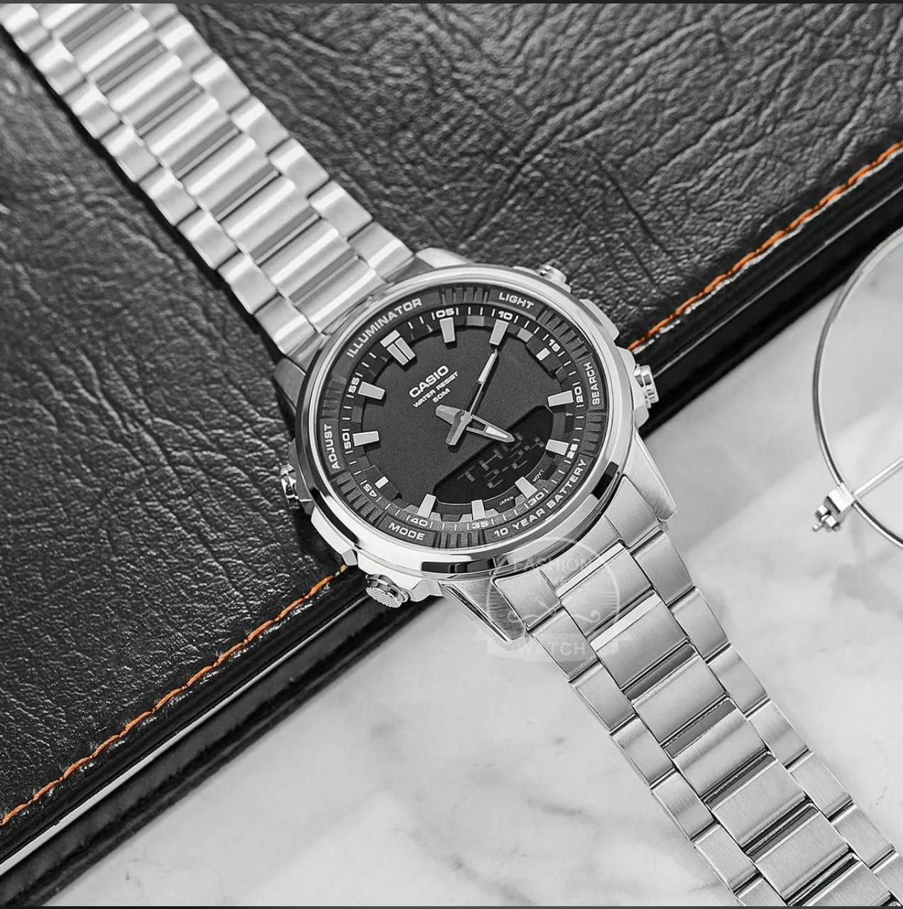 Silver Casio watch with black dial on a textured surface