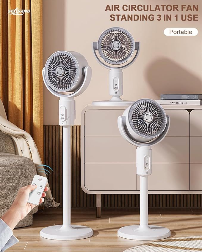 Portable air circulator fan with remote control on a wooden floor.