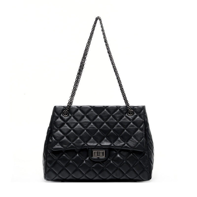 Black quilted handbag with a chain strap on a white background