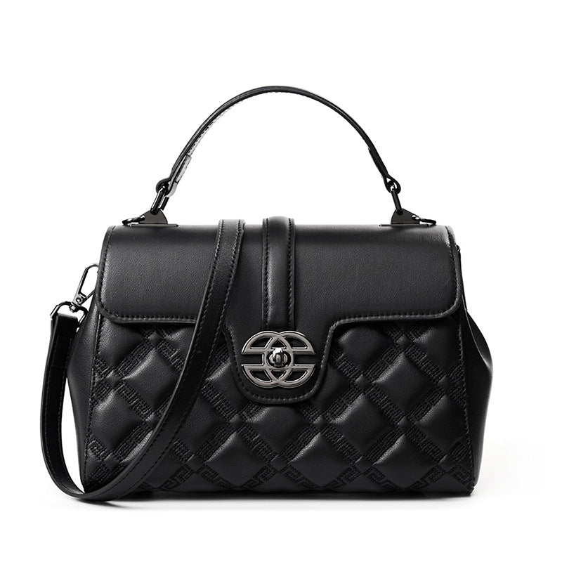 A black quilted leather handbag with a top handle, a detachable shoulder strap, and a silver-tone interlocking CC logo clasp on the front flap.