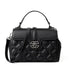 A black quilted leather handbag with a top handle, a detachable shoulder strap, and a silver-tone interlocking CC logo clasp on the front flap.