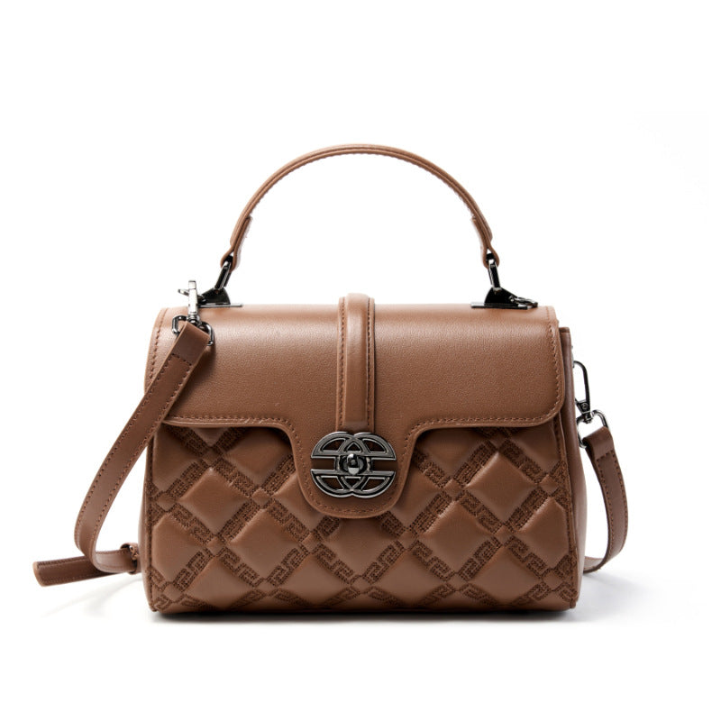 Brown quilted handbag with a decorative clasp on a white background