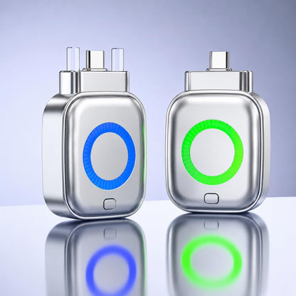 Two metallic electronic plug-in devices shown side by side on a reflective surface against a soft blue gradient background. The left device has a blue glowing circular indicator, and the right device has a green glowing circular indicator.