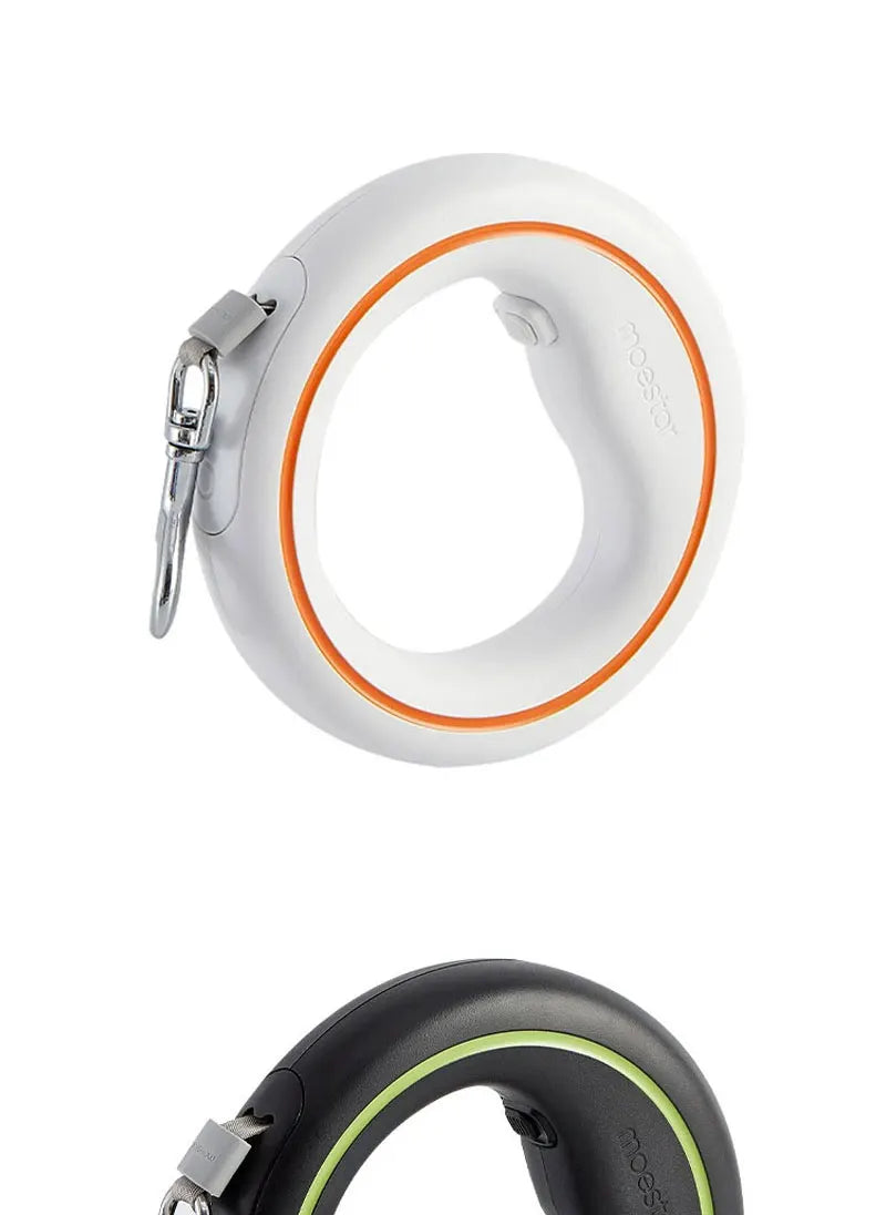 Two retractable dog leashes shown on a white background: one white with an orange ring and silver clasp, and one black with a light green ring and silver clasp.