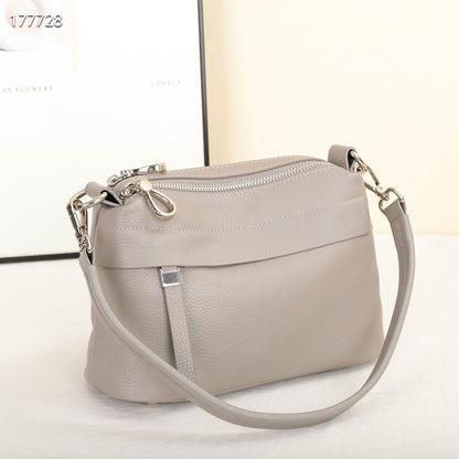 Light gray handbag with a strap on a white background