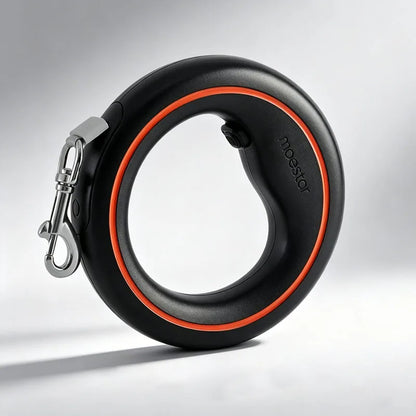 A black retractable dog leash with a bright orange accent ring and a silver metal clasp, shown on a light gray studio background. The brand name &