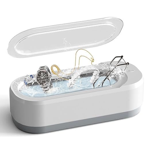 Jewelry cleaner with jewelry items inside on a white background