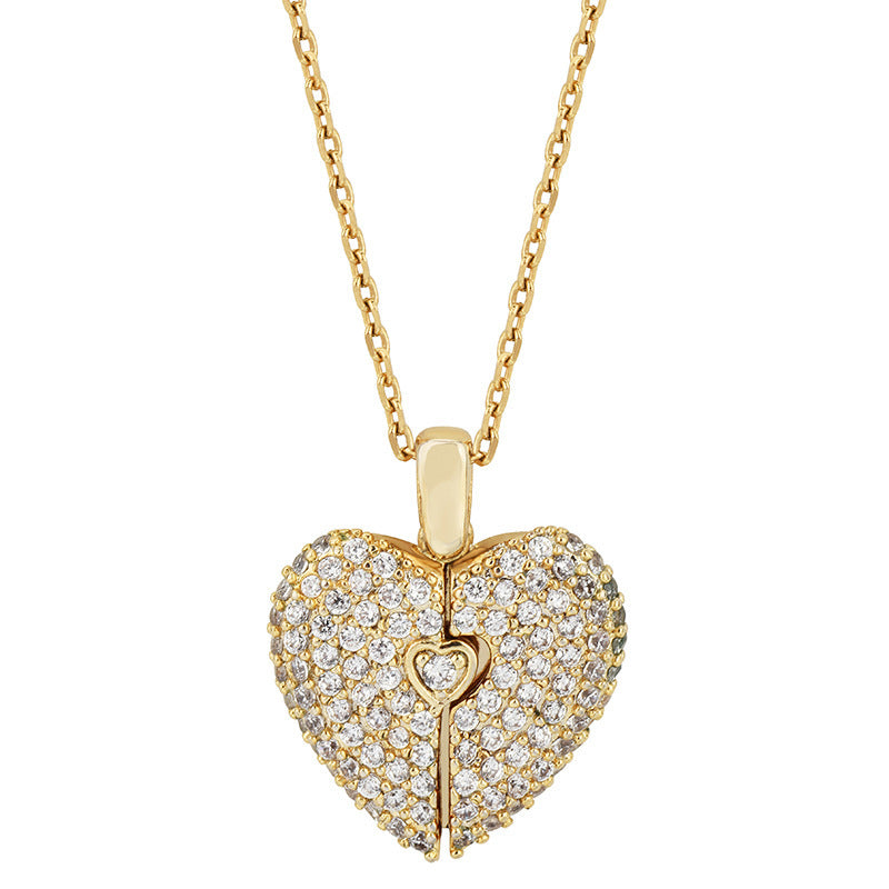 A gold heart-shaped pendant necklace paved with clear stones, featuring a small keyhole detail in the center, shown on a white background.